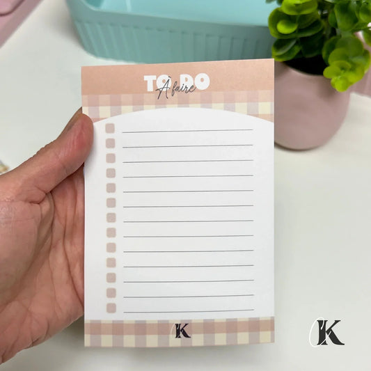 Retro plaid sticky note to-do list held by hand, pastel colors, lined for planning